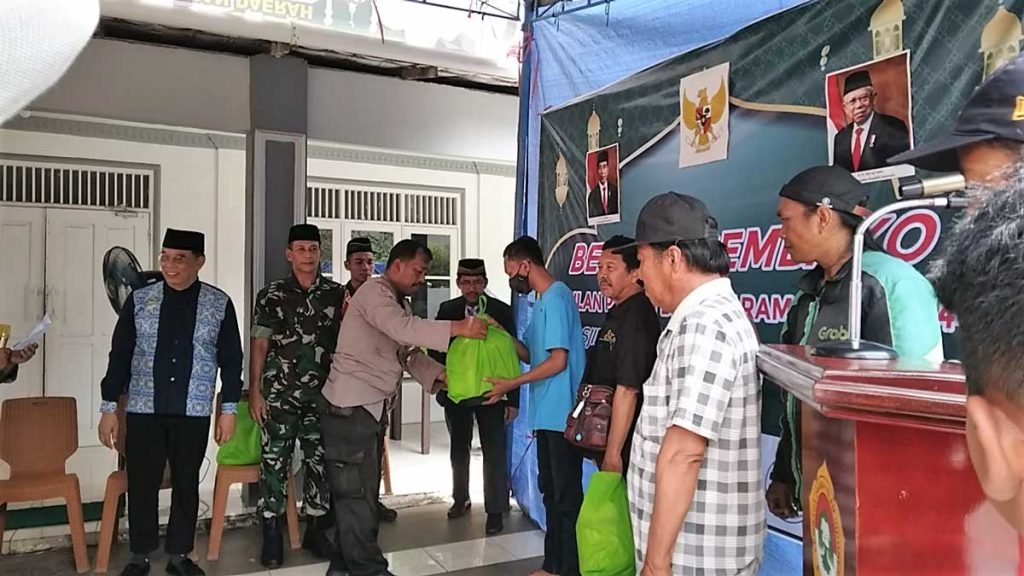 Bhabinkamtibmas Kel. Batu Ampar Eko menyerahkan paket sembako kepada salah satu warga sekitar Masjid An Nasai, disaksikan Danramil 0905-01 Balikpapan Utara Tengah Mayor CZI Eko Miyanto dan Ketua DPD LDII Kota Balikpapan H. Herry Fathamsyah. Foto: LINES