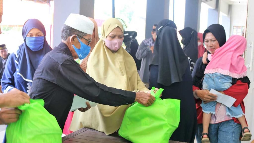 Salah satu tokoh masyarakat H. Nase ikut membantu membagikan paket sembako. Foto: LINES