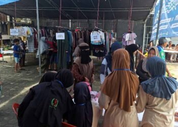 Warga mengantre mendapatkan baju barokah di pelataran Masjid Al Manshurin, Kel. Damai Baru, Kec. Balikpapan Kota, Minggu (16/3/2025). Foto: LINES